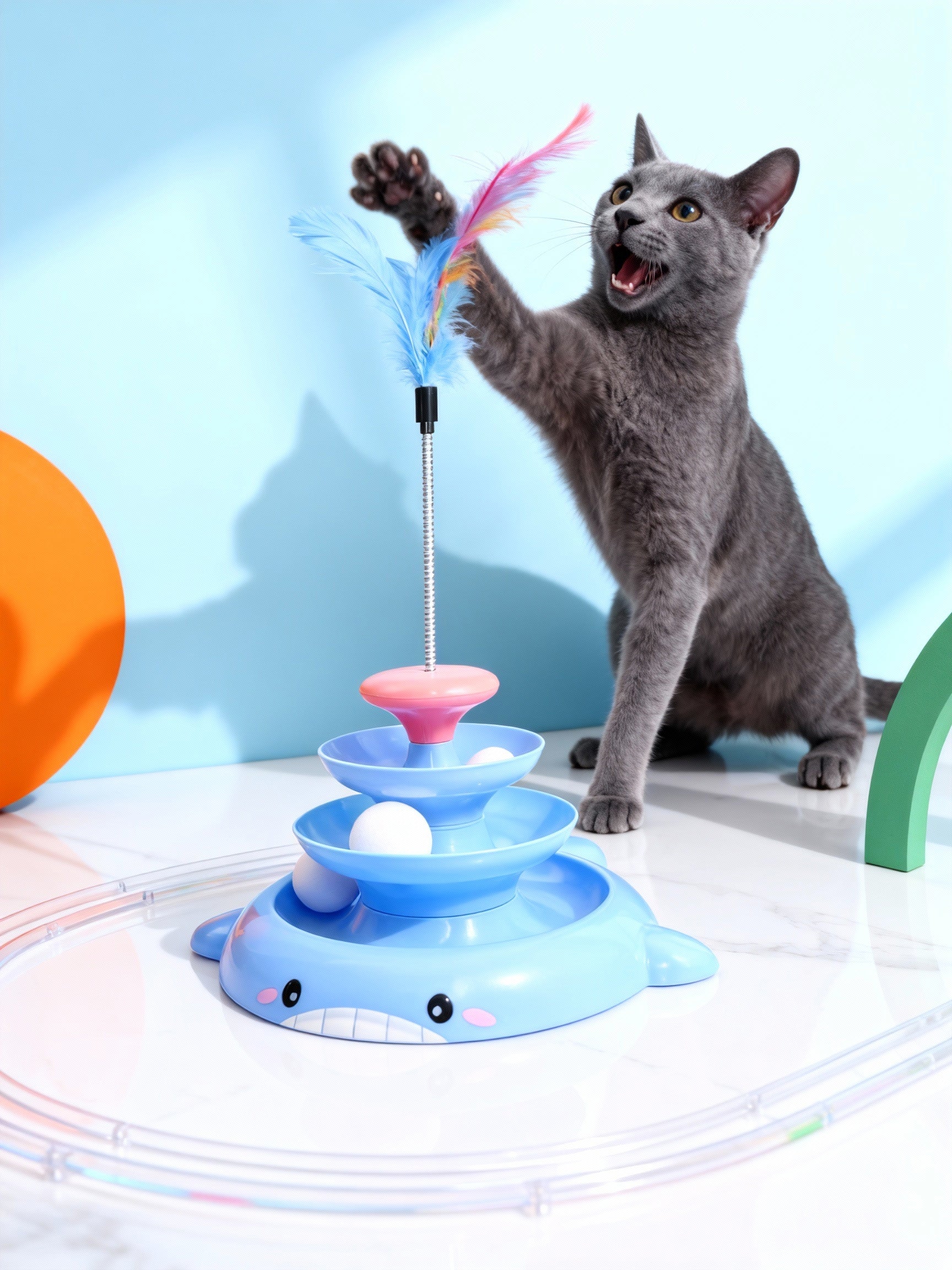 Cat playing with a colorful toy featuring feathers and balls on a light blue background